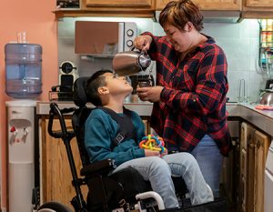 Medically Fragile Children group image - boy in wheelchair with caregiver