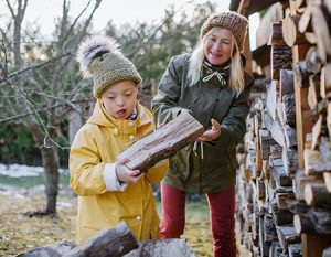 Young boy with mom stacking fire wood